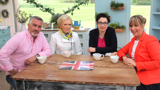 Hollywood poses in a tight pink button-down next to his delightful former co-hosts. Image via PBS.